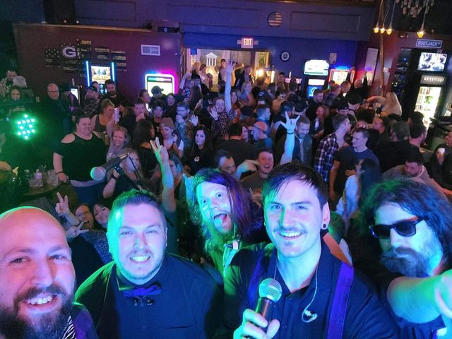 Band members and a full crowd packed in together after a show